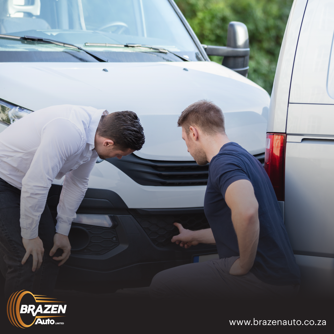 Two men inspecting damage on a white vehicle, representing where to sell a damaged car in Gauteng.